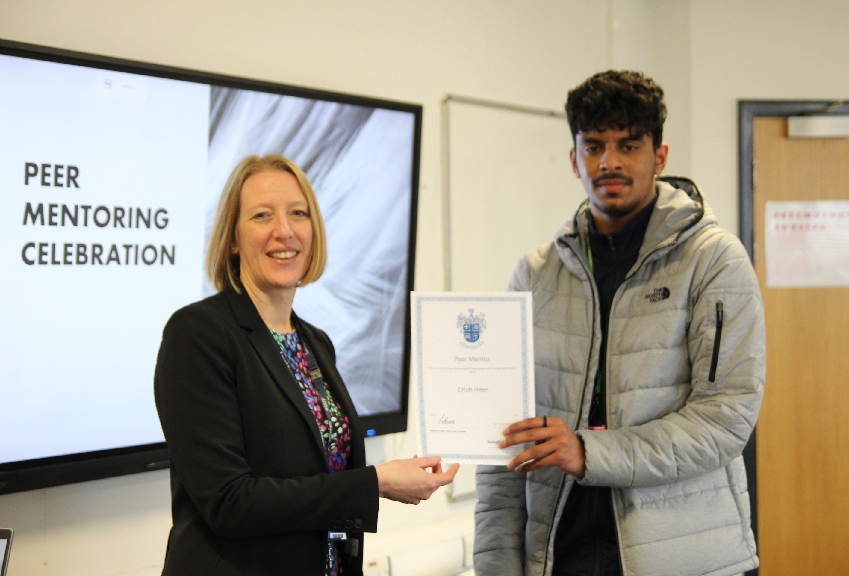 Crish Heer A Levels - Geography, Environmental Science, Economics student receiving a peer mentor award from Lucy Howes