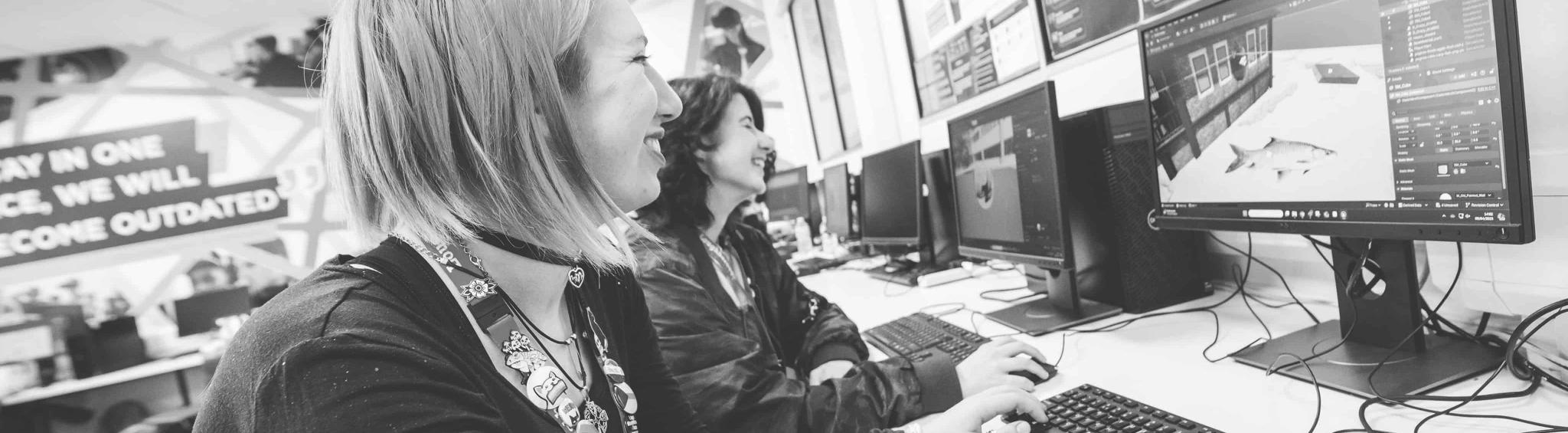Employers sitting at desk with employees looking at a computer screen