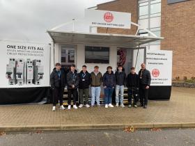 Students and staff stand outside the mobile showroom