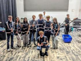 T Level Media Students with The Mercians setting up in the background