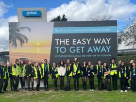 Travel and Aviation Students at the welcome sign of East Midlands Airport