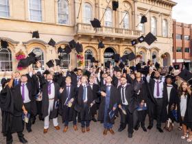 Graduates at Loughborough Town Hall throw their caps