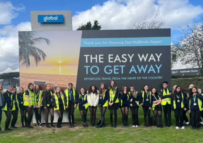 Travel and Aviation Students at the welcome sign of East Midlands Airport
