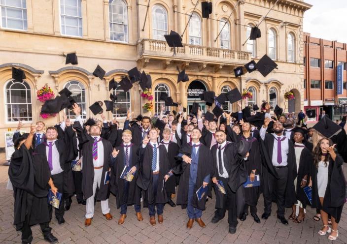 Graduates at Loughborough Town Hall throw their caps