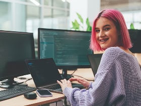 A student sitting at a desk and working on a computer