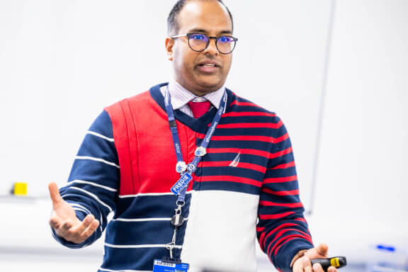 Loughborough College staff member standing at the front of their classroom talking about the subject