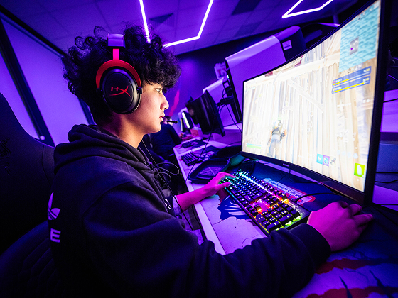Person wearing headphones and sitting at a gaming computer
