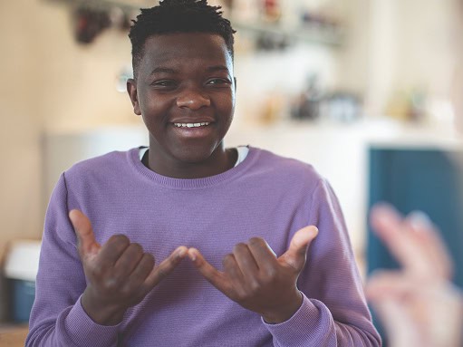A student performing British Sign Language, BSL