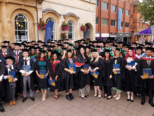 Graduated students standing in a large group outside Loughborough Town Hall after their ceremony
