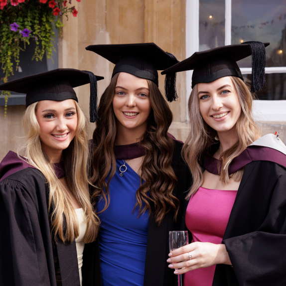 Students with their graduation gowns on posing for the camera