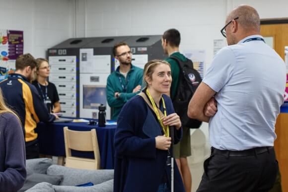 Staff standing answering questions and talking to people who have attended an HE Open Day