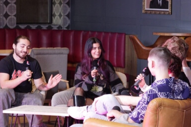 Media student sitting down interviewing other student for LSU TV