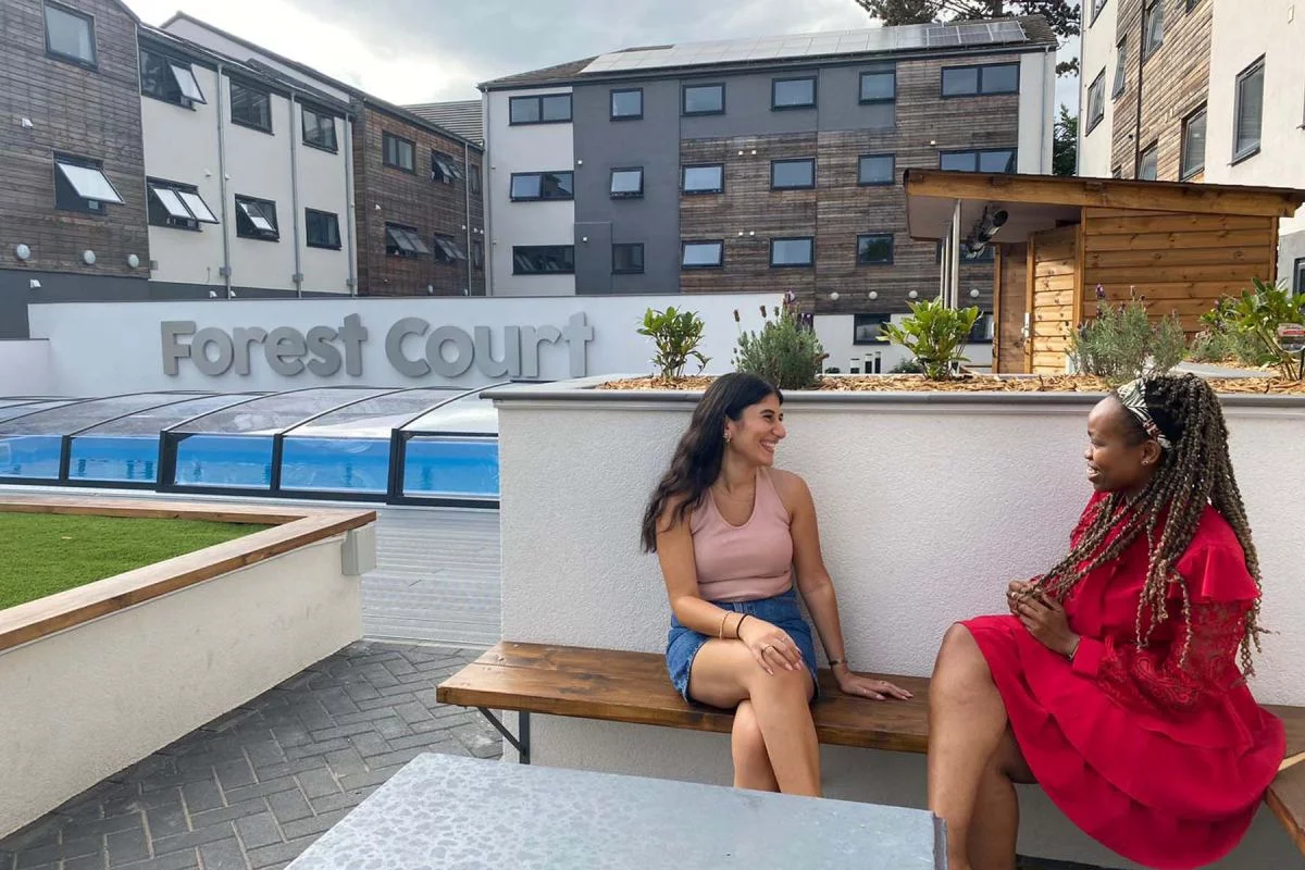 Two students smiling outside Forest Court, a Student Beehive accommodation