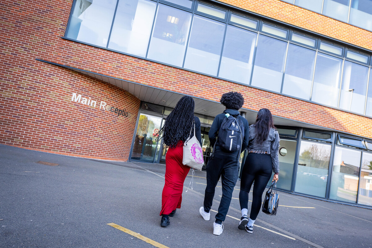 A group of students walking towards a building