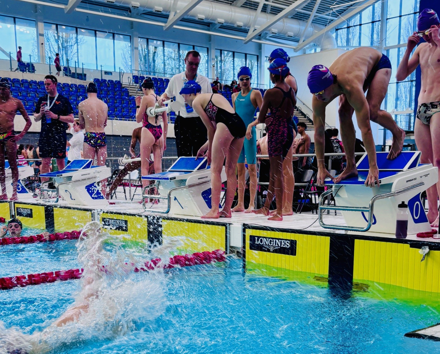 A group of swimmers poolside.