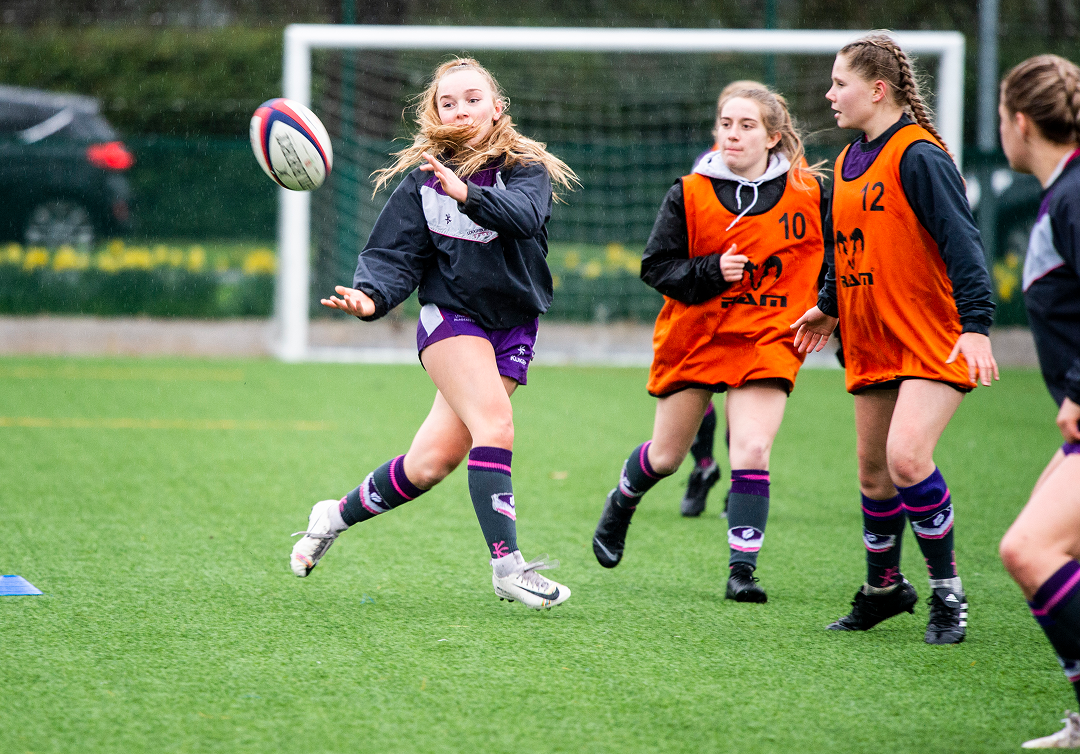A female rugby player passing the ball