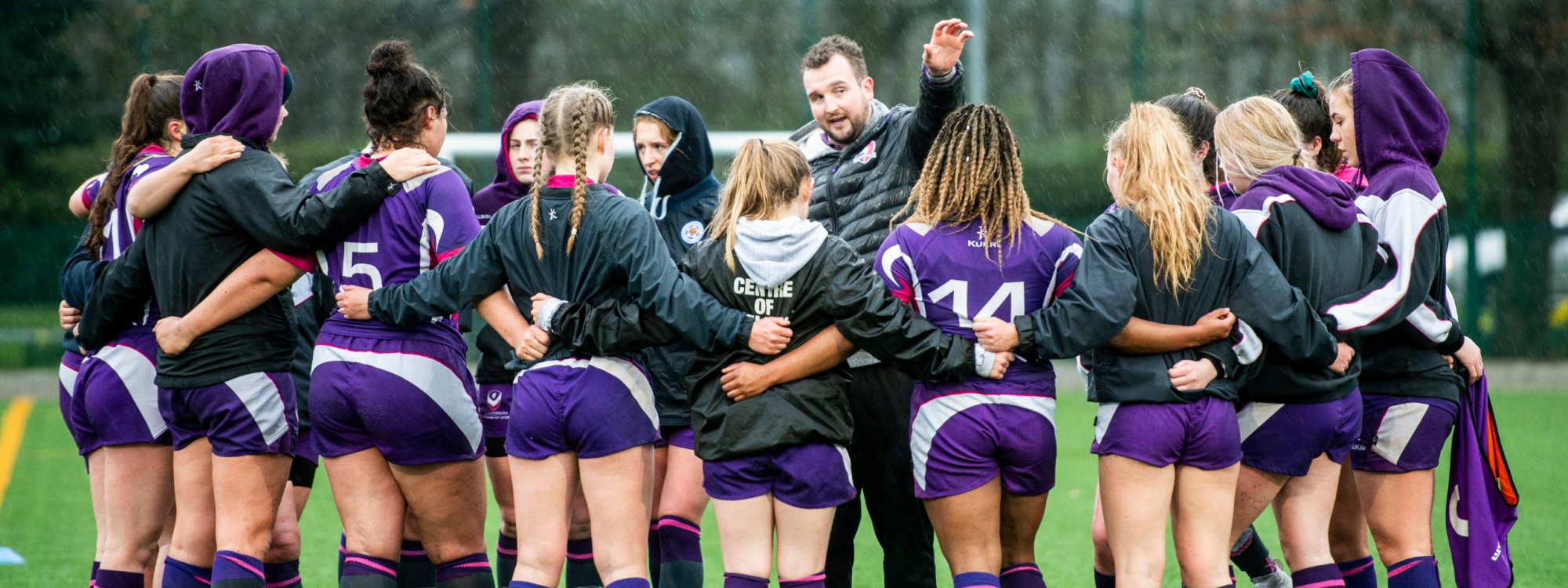 A huddle of female elite sports athletes.