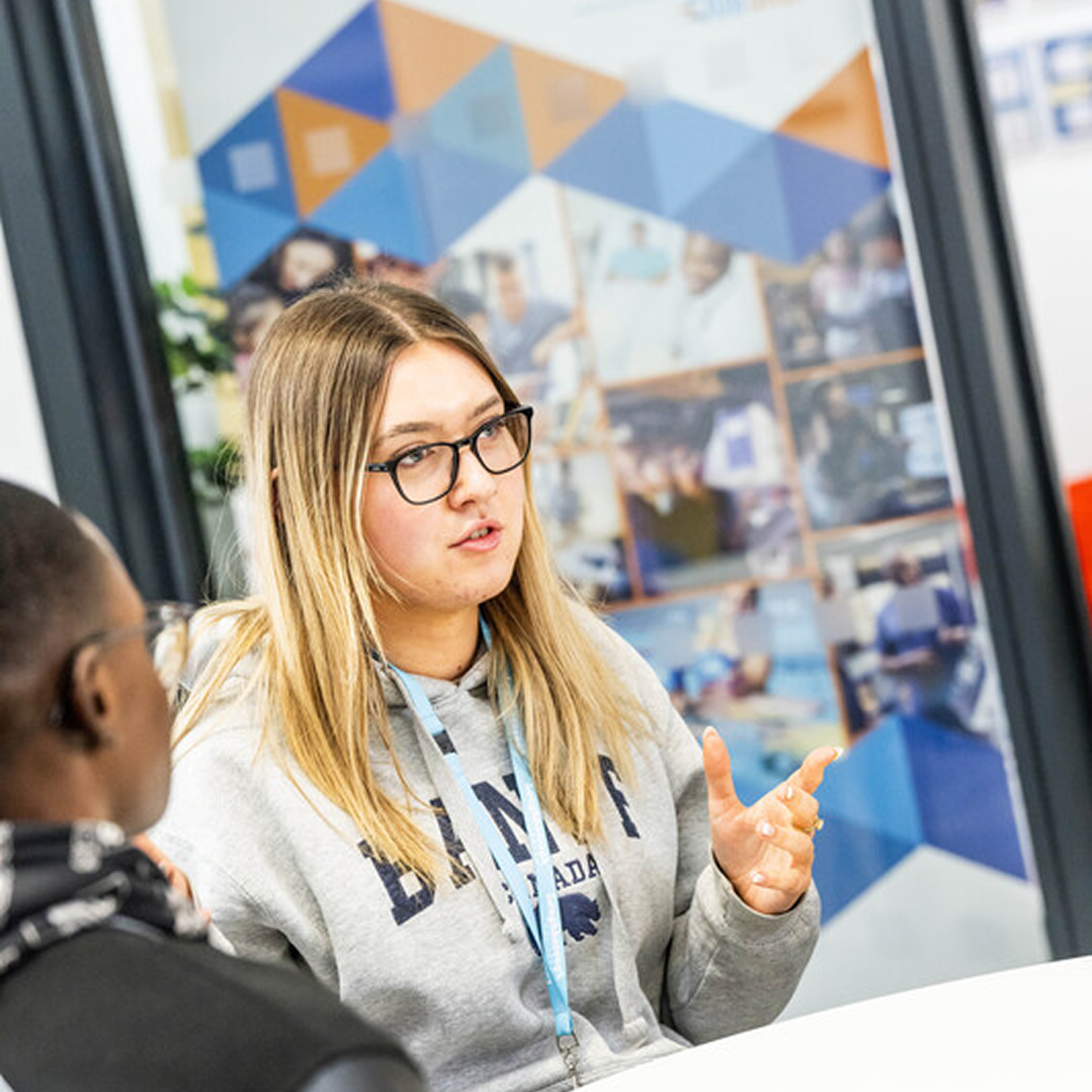 Person sitting at a desk, talking to someone