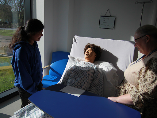 Two people attending to care of practice dummy